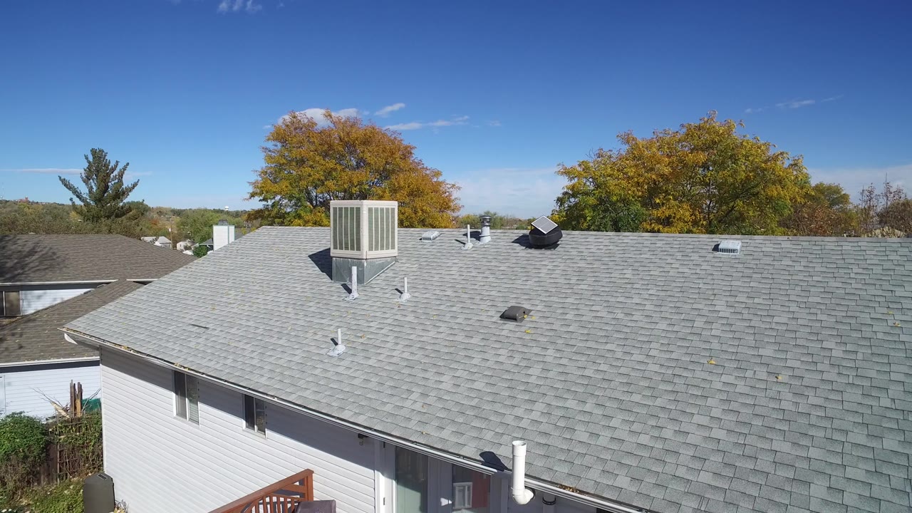 A slightly later view in Hidden Lake, Colorado keeps the gray roof dominant while showing roof vents, a skylight or roof fixture, distant trees, and no visible people.