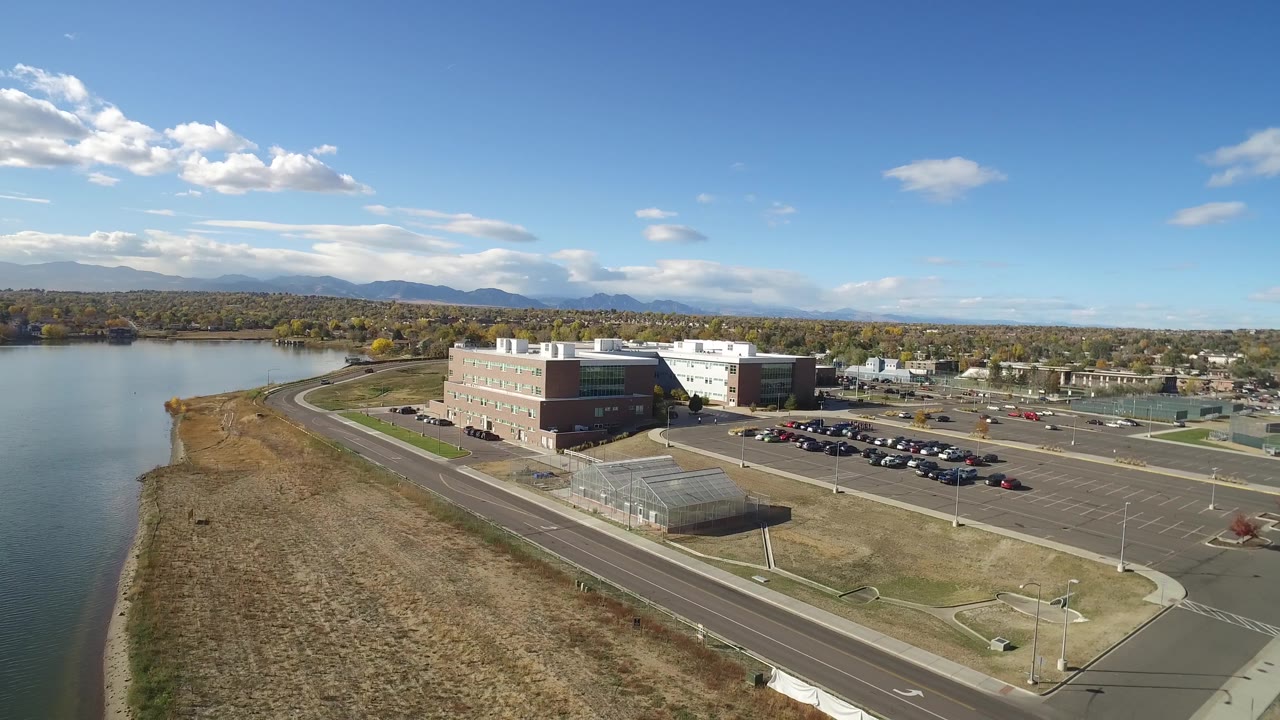 Office building and parking lots beside a lake from above.