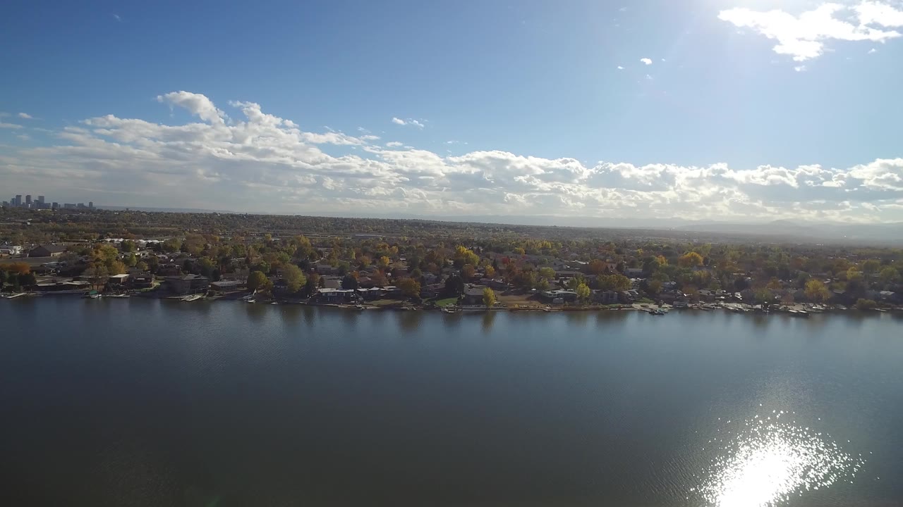 High lake view with reflective water, shoreline houses, and distant horizon.