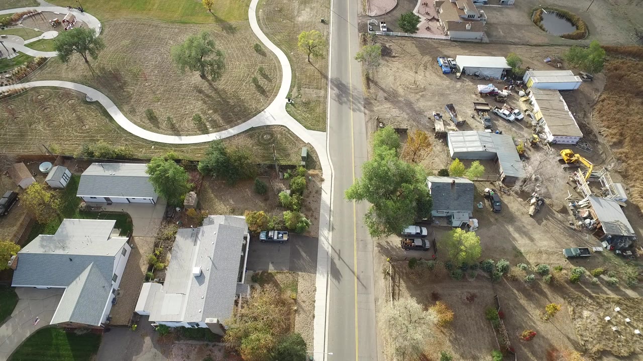 Overhead aerial view of a rural homestead beside a paved road.