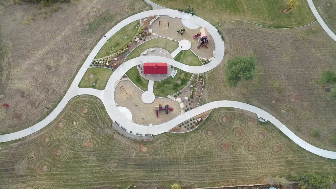 High overhead view of paths wrapping around a small playground and shelter.