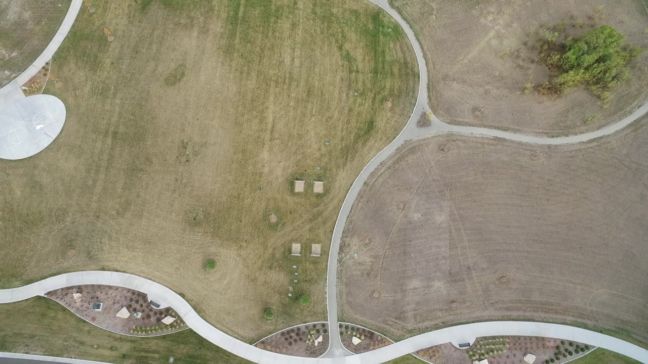 High overhead frame of the Hidden Lake, Colorado course showing a broad fairway area, pale winding cart paths, small square utility covers, and no visible people.
