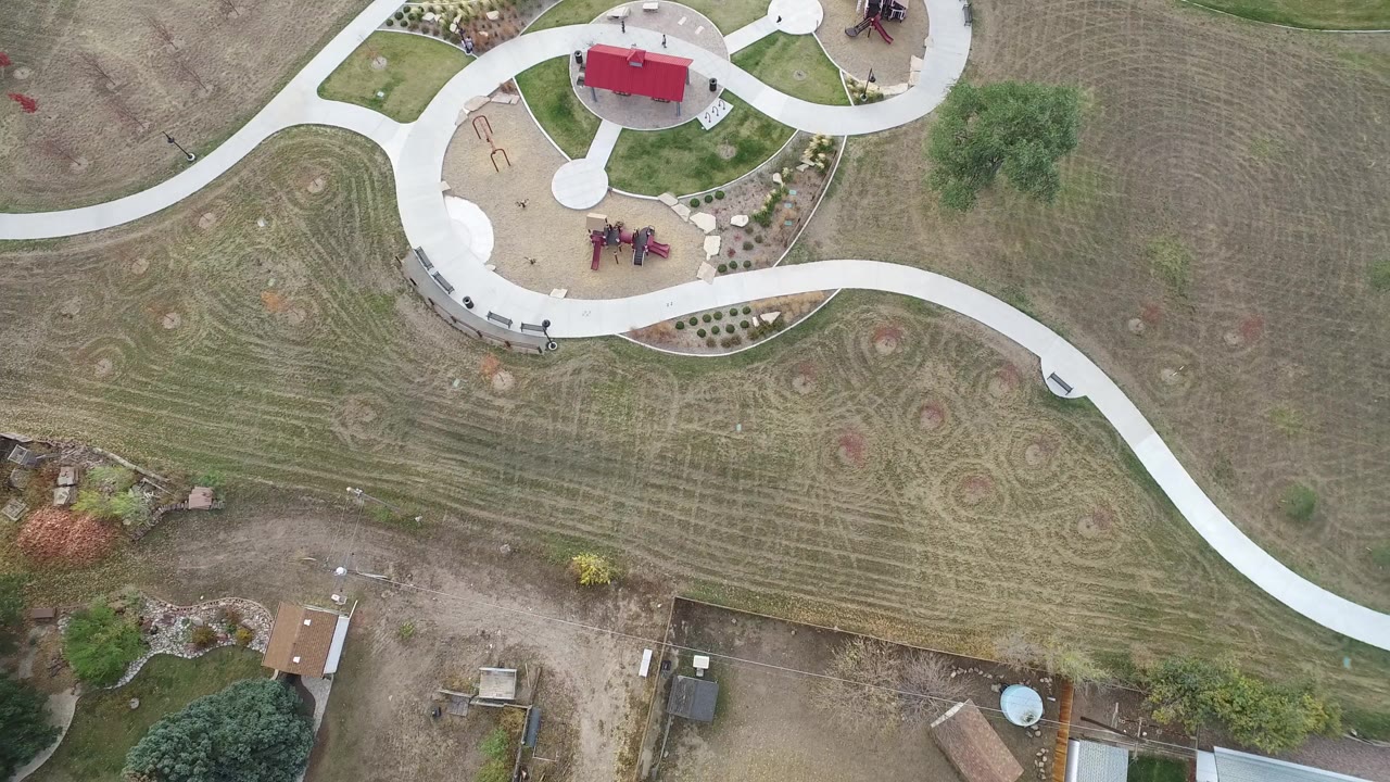 Overhead view of a park path, playground, and mowed grass.