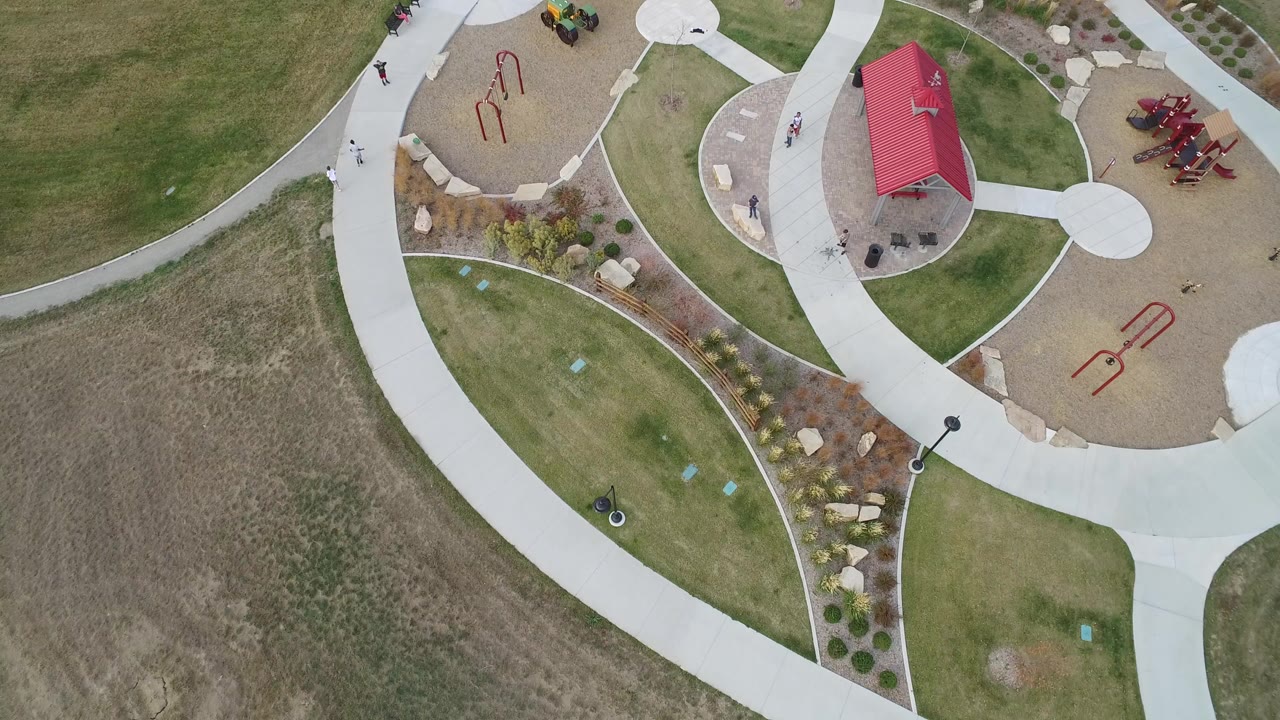 Overhead view of a public park with curved paths and playground areas.