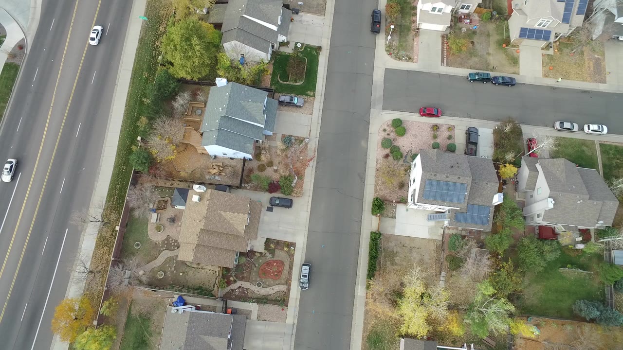 Overhead view of houses beside a multi-lane avenue and residential streets.