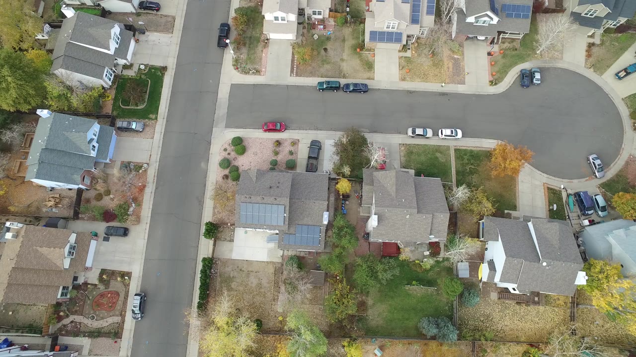 Top-down aerial frame of a Hidden Lake, Colorado cul-de-sac with houses, driveways, parked cars, trees, and no visible people at the start of the clip.