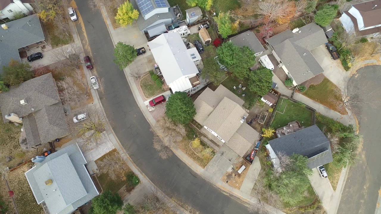 Overhead view of suburban houses along curved streets.