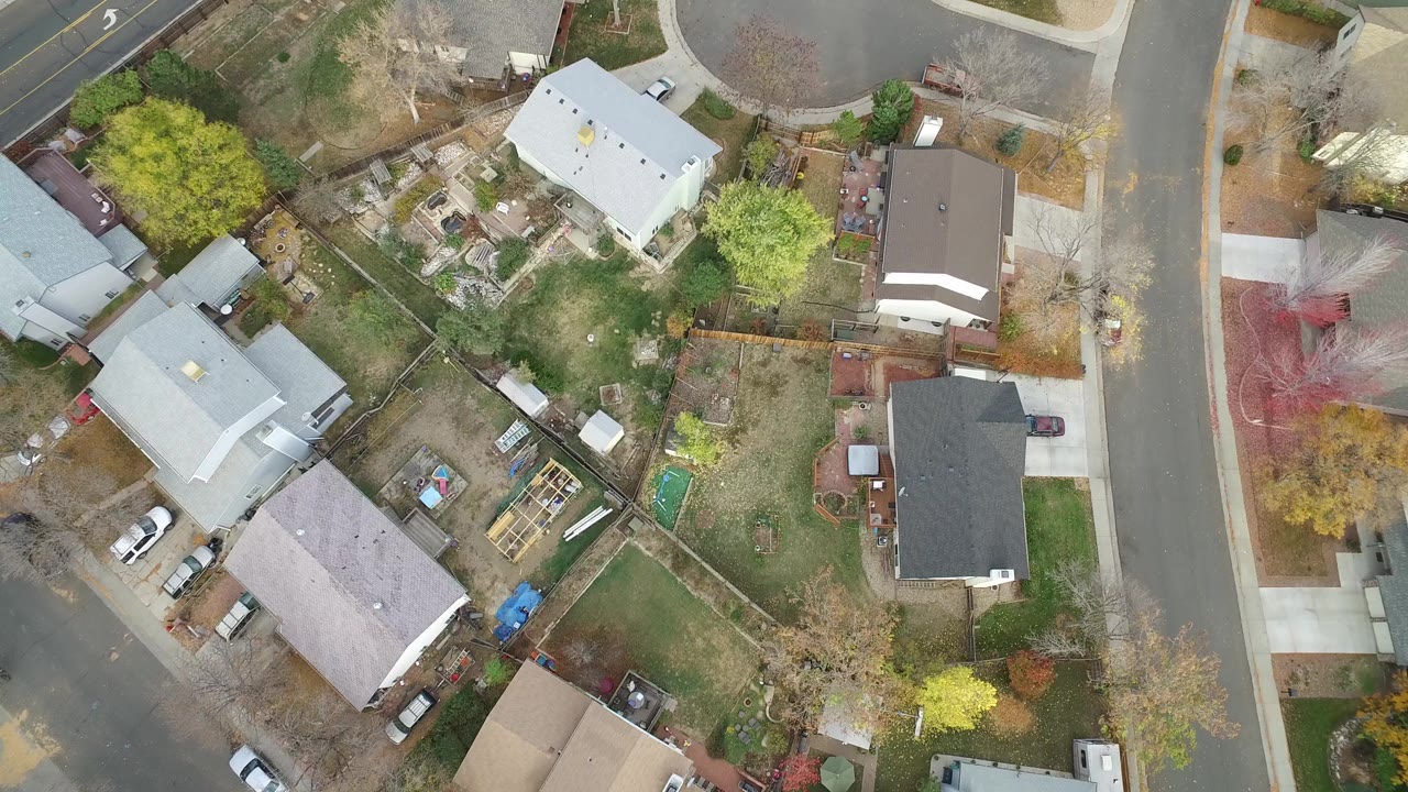 Overhead view of houses, yards, and a curved residential street.