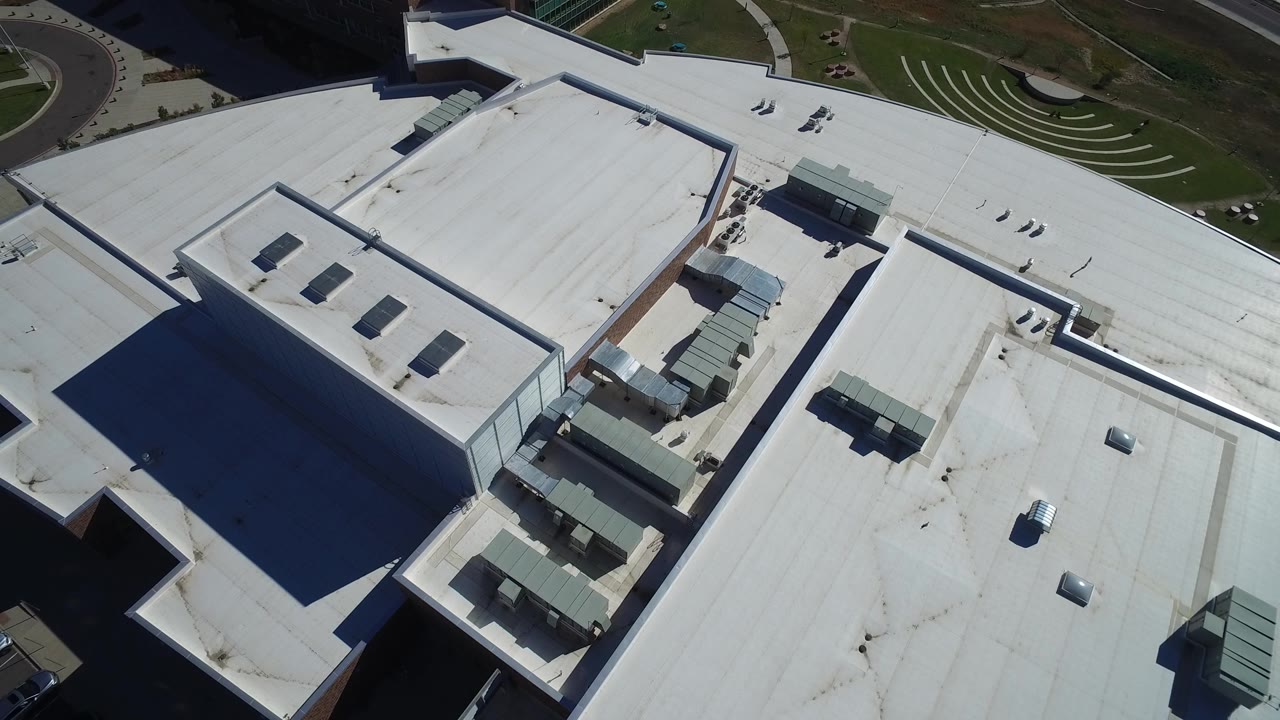 Overhead aerial frame in Hidden Lake, Colorado showing white flat roofs, rooftop units, building shadows, and no visible people.