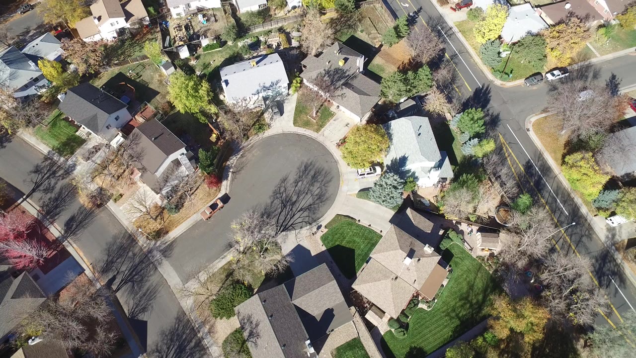 Overhead frame from Hidden Lake, Colorado showing a cul-de-sac, detached homes, lawns, trees, parked cars, and no visible people.
