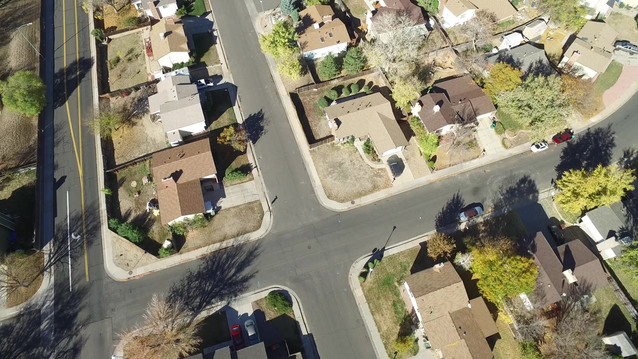 Overhead frame of Hidden Lake, Colorado houses and curved residential streets, with tan roofs, small yards, parked cars, and no visible people.
