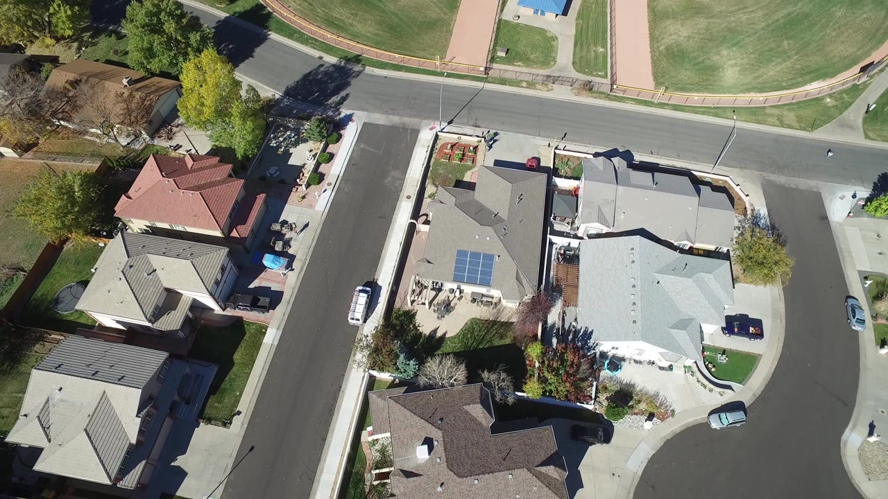 Overhead frame in Hidden Lake, Colorado showing clustered houses, a street crossing near the top, parked vehicles, lawns, and no visible people.