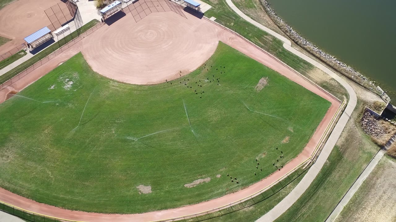 High aerial frame in Hidden Lake, Colorado, with the outfield centered, the infield at the top, the lake along the right edge, and no visible people.