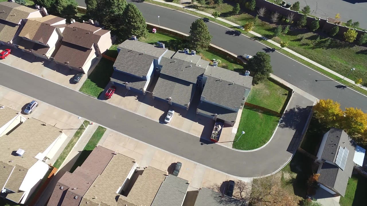 Overhead view of suburban houses and a curved residential street.