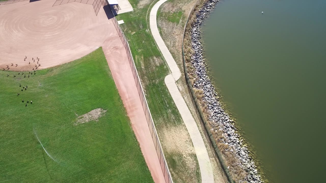 High overhead view of a baseball field edge and lake.