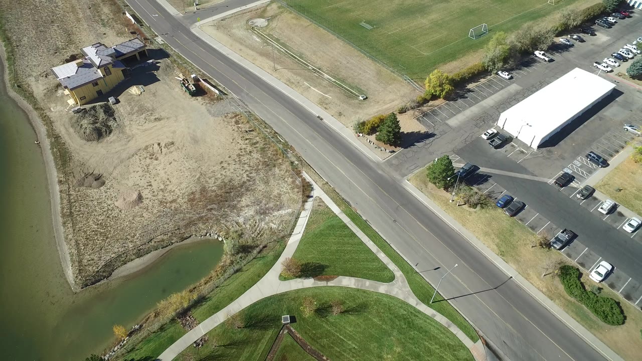 Overhead view of road, parking lot, fields, and water channel.