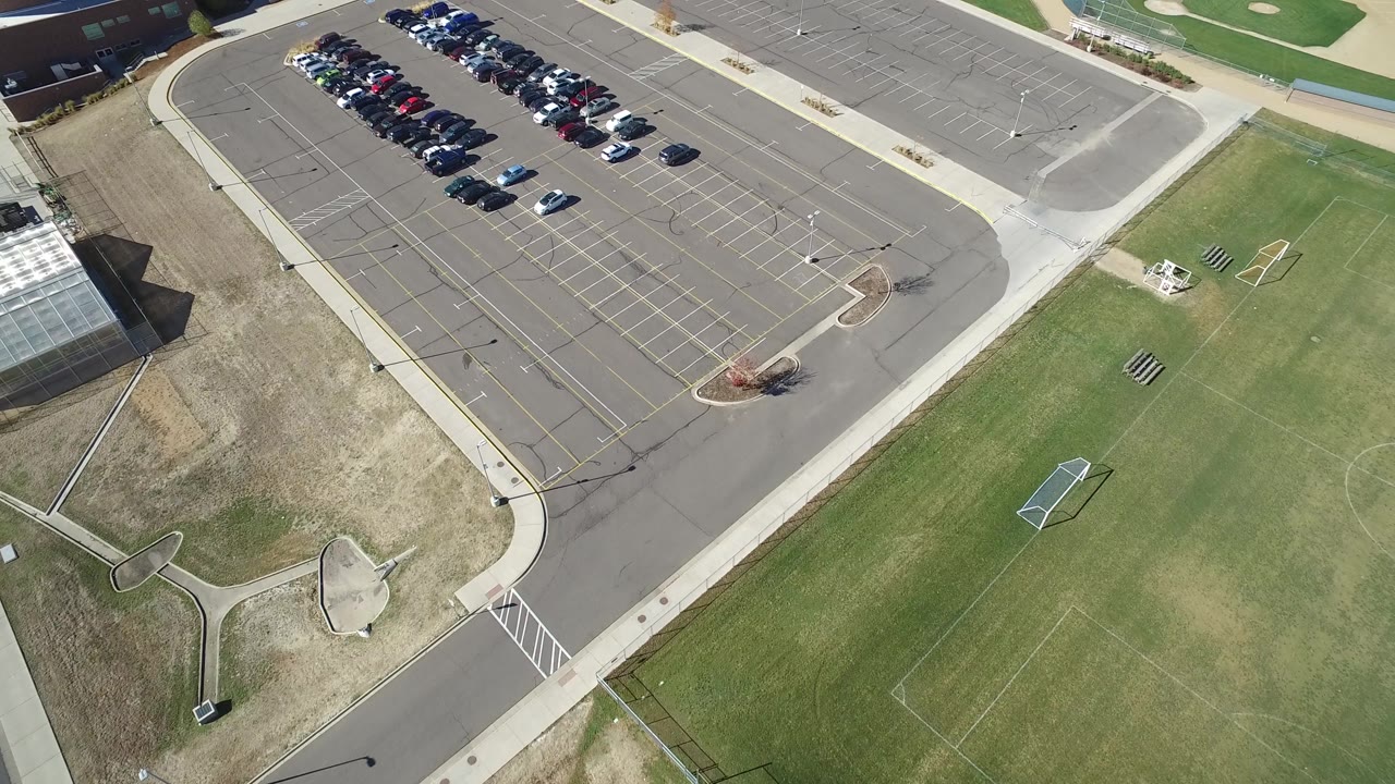Aerial parking lot with sports field and sidewalks