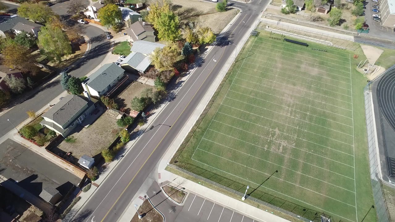 Aerial view of a football field beside residential streets and homes.