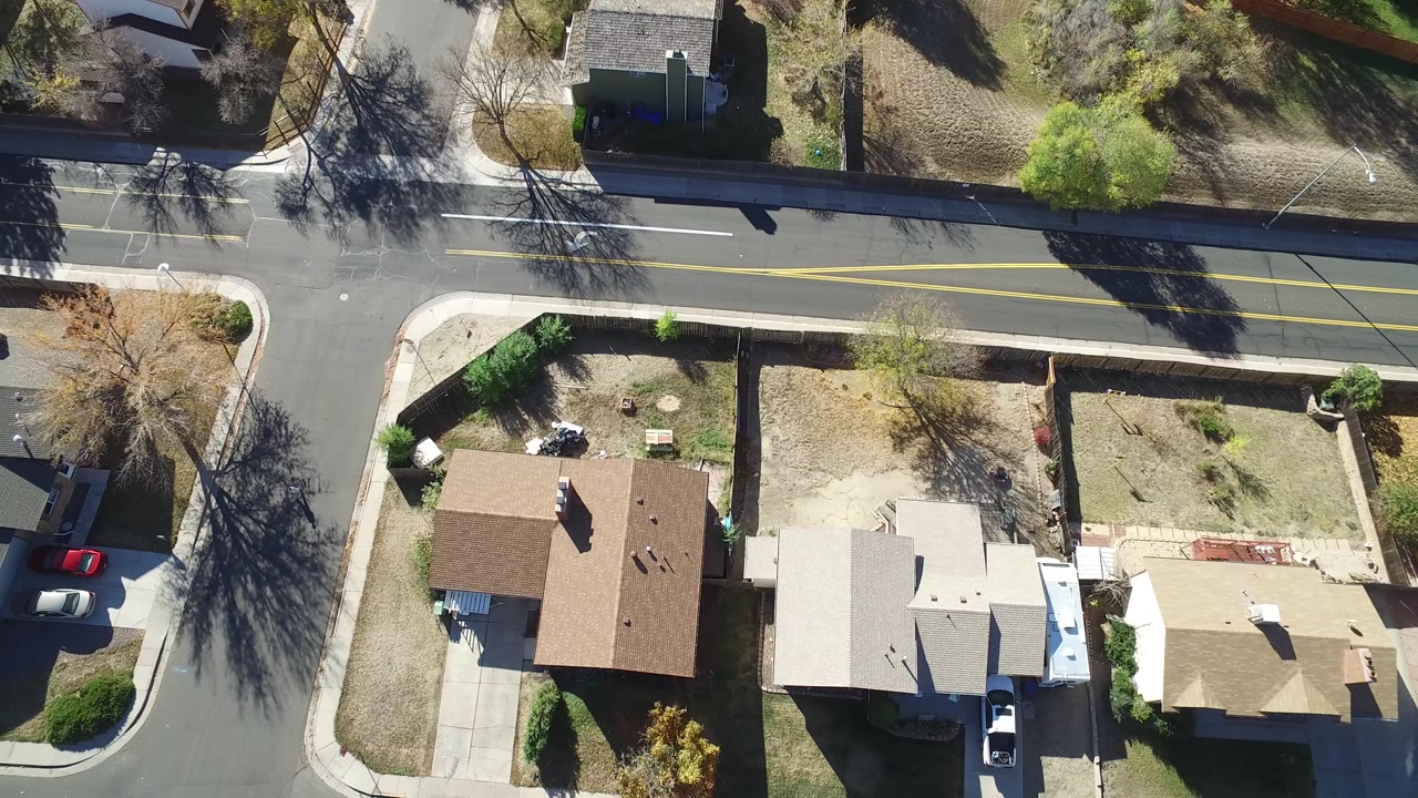 Overhead view of suburban houses beside a two-lane road.