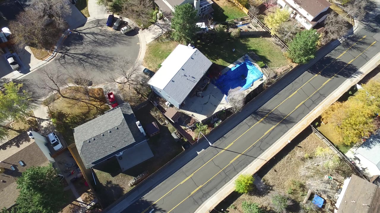 Overhead suburban road beside houses and tree shadows