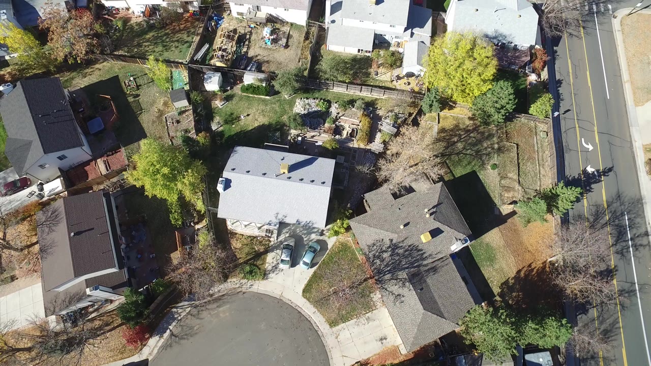 Overhead view of houses, yards, trees, a cul-de-sac, and a road