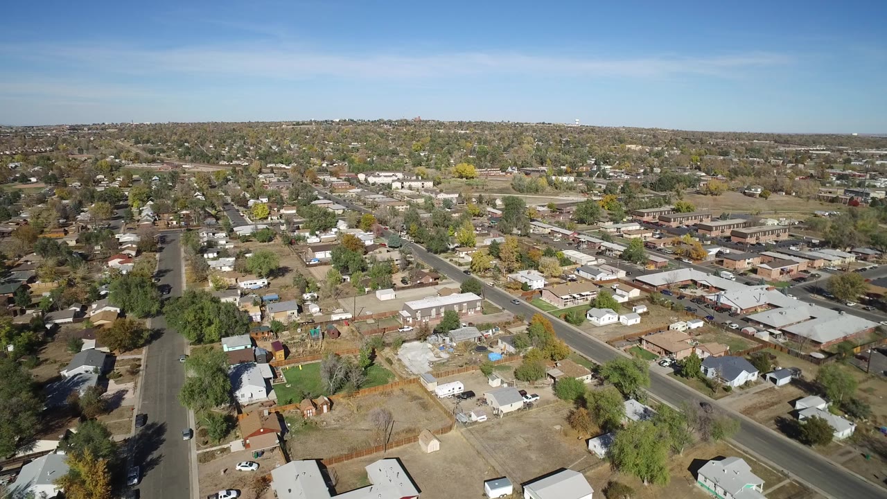 Wide aerial view of rooftops and streets across a quiet town.