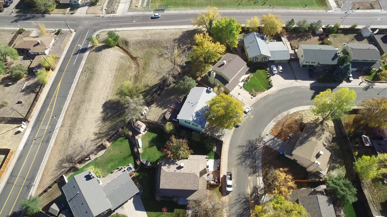 Overhead view of a cul-de-sac, houses, road, and open field.
