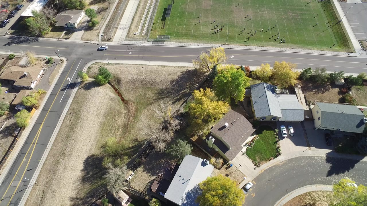 Overhead road, houses, trees, and green field.
