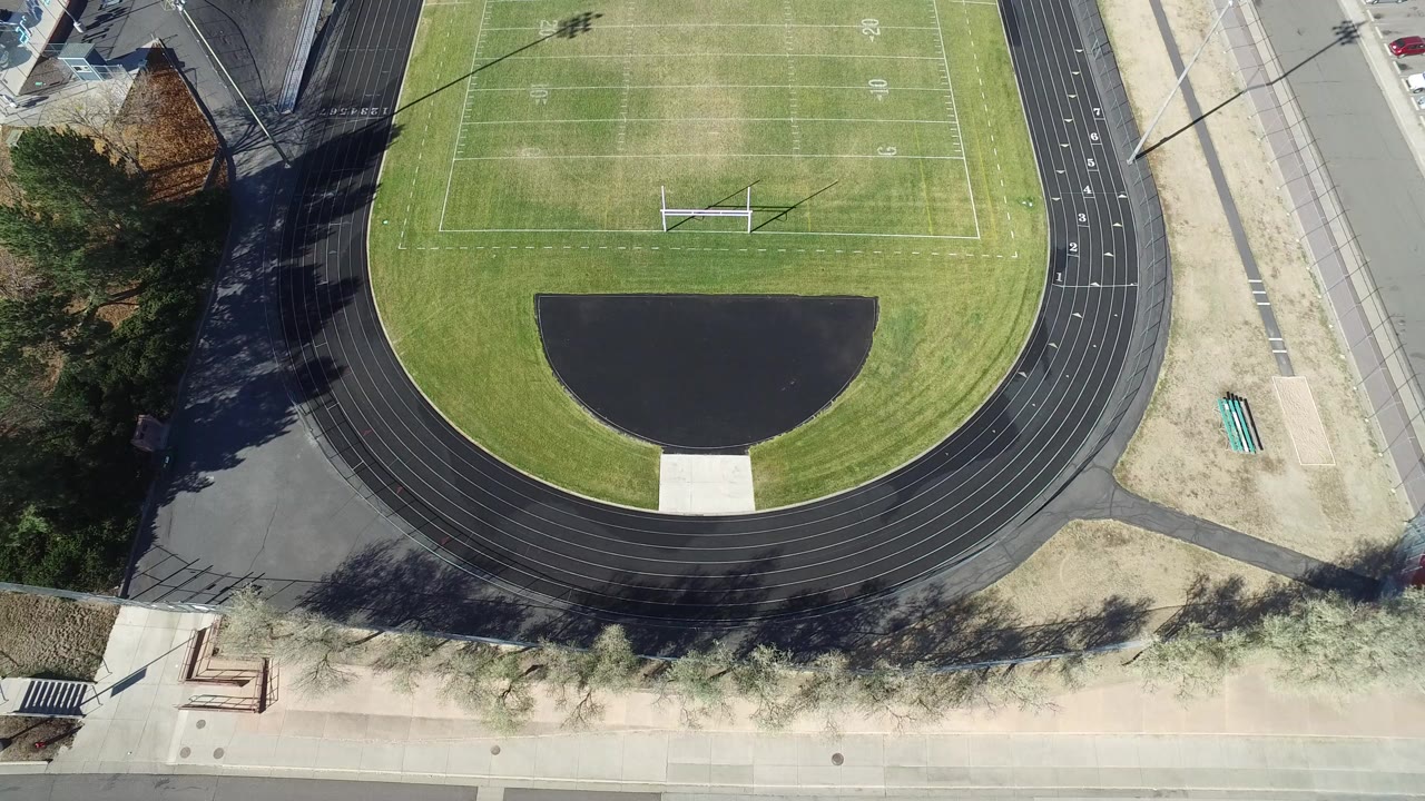 Overhead view of a football field and black running track