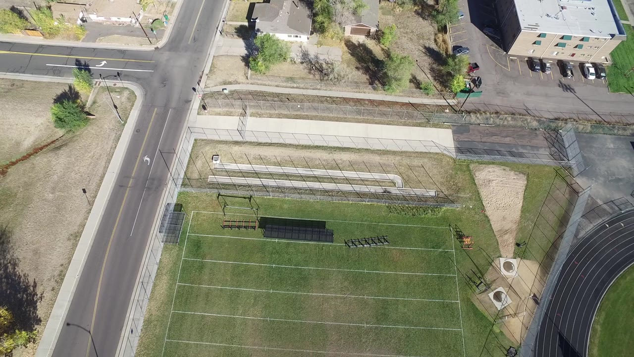Overhead view in Hidden Lake, Colorado, showing the field more centered beneath bleachers and a road intersection, with no visible people.