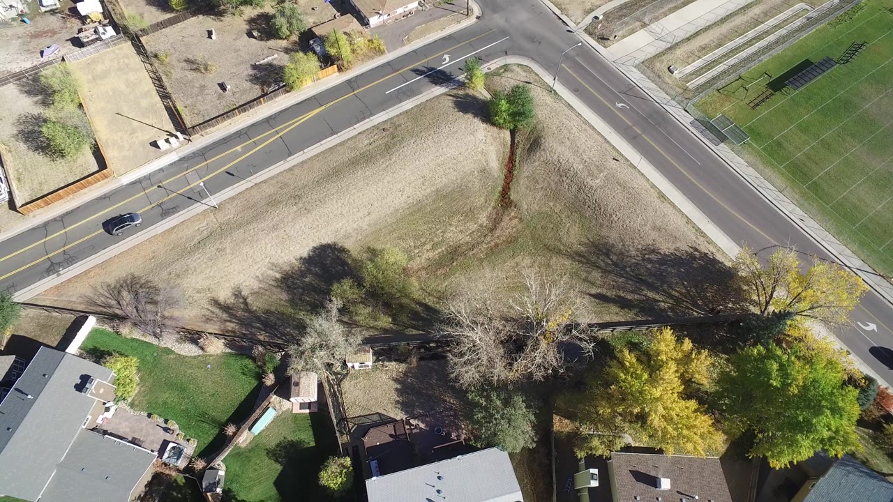 Top-down neighborhood view with a car on the road and houses below.