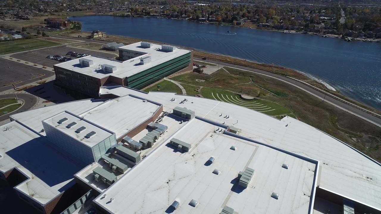 Aerial view of flat-roof commercial buildings beside a lake.