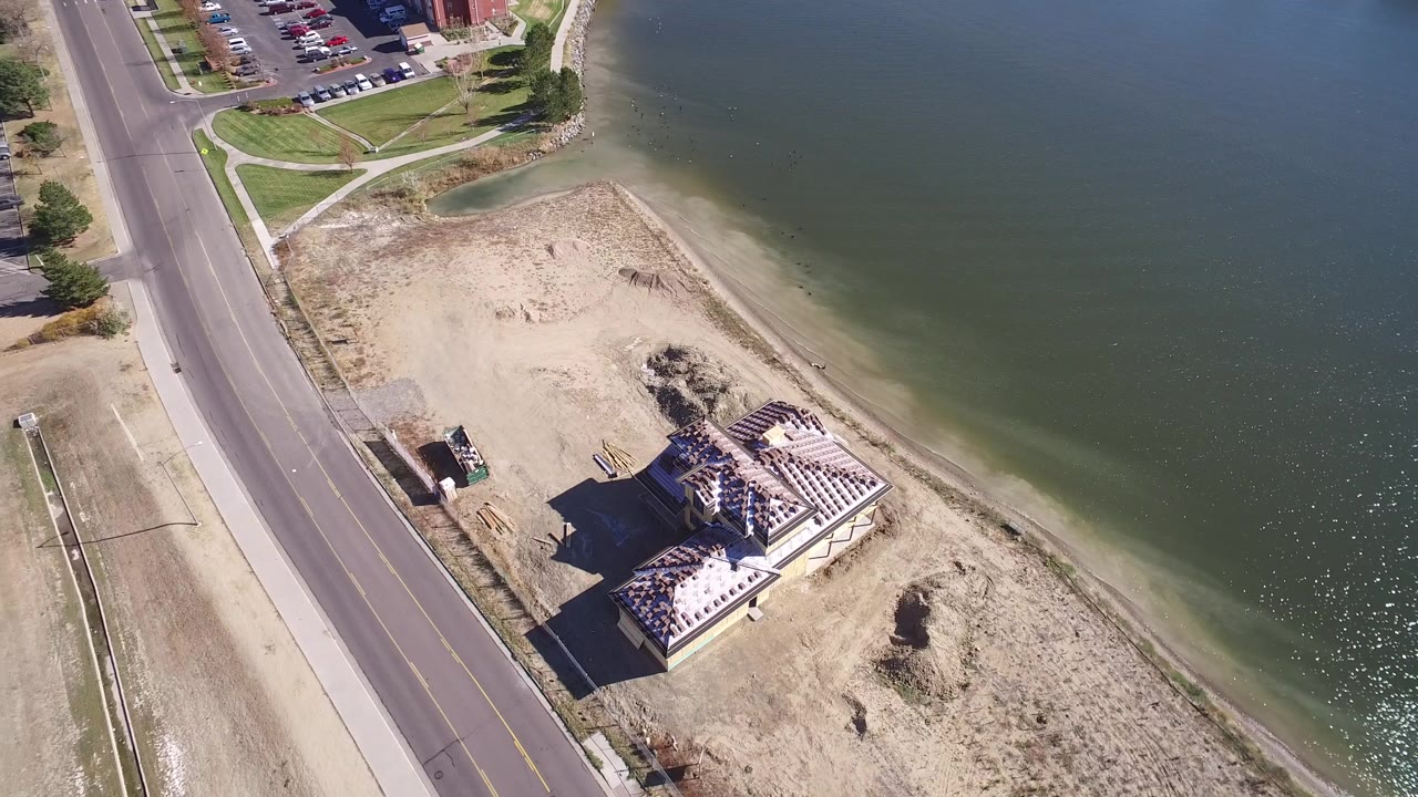 Aerial view of a lakeside construction lot beside a road
