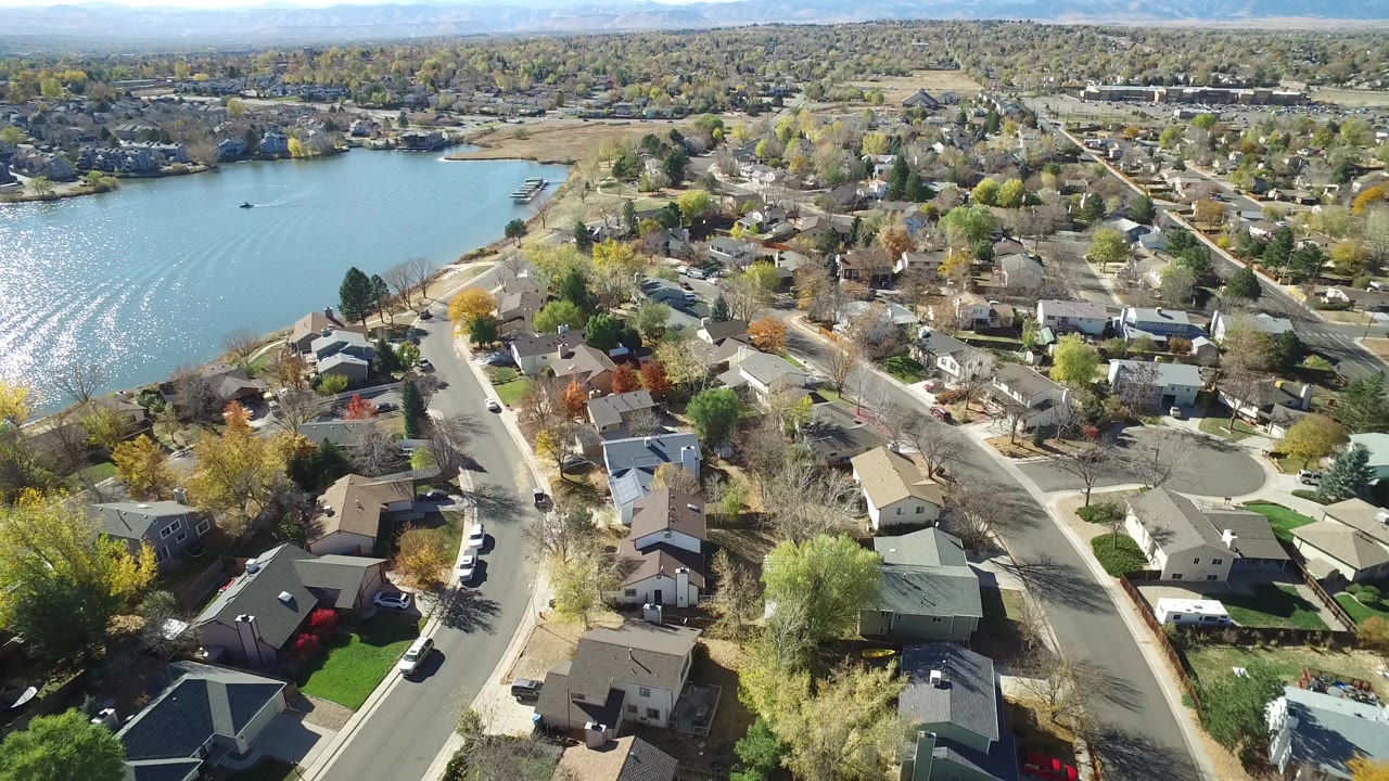 Aerial view of a lake beside residential streets and houses.