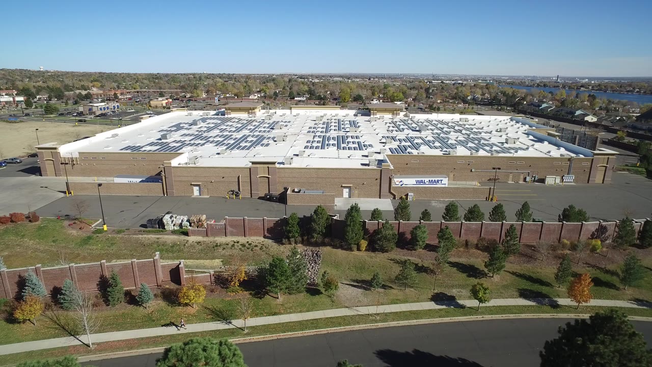 Aerial view of a large tan retail building and mostly empty parking lot