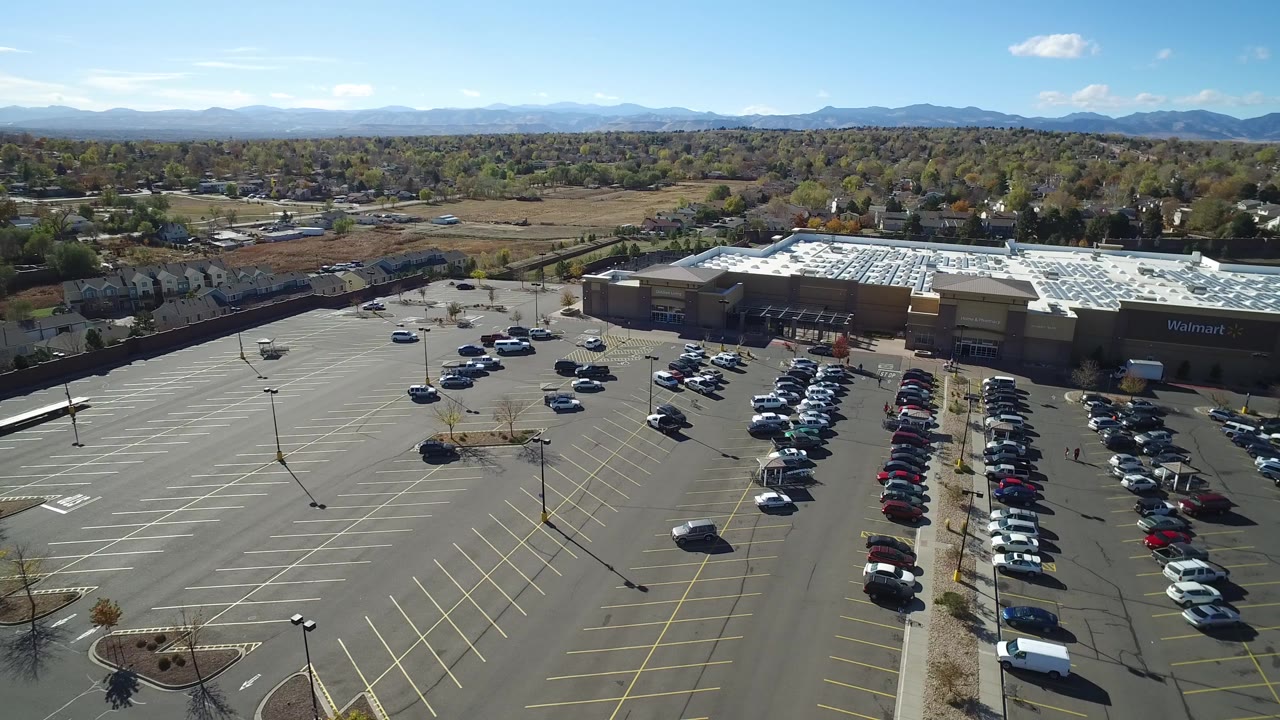 Aerial view of a commercial parking lot and low retail buildings