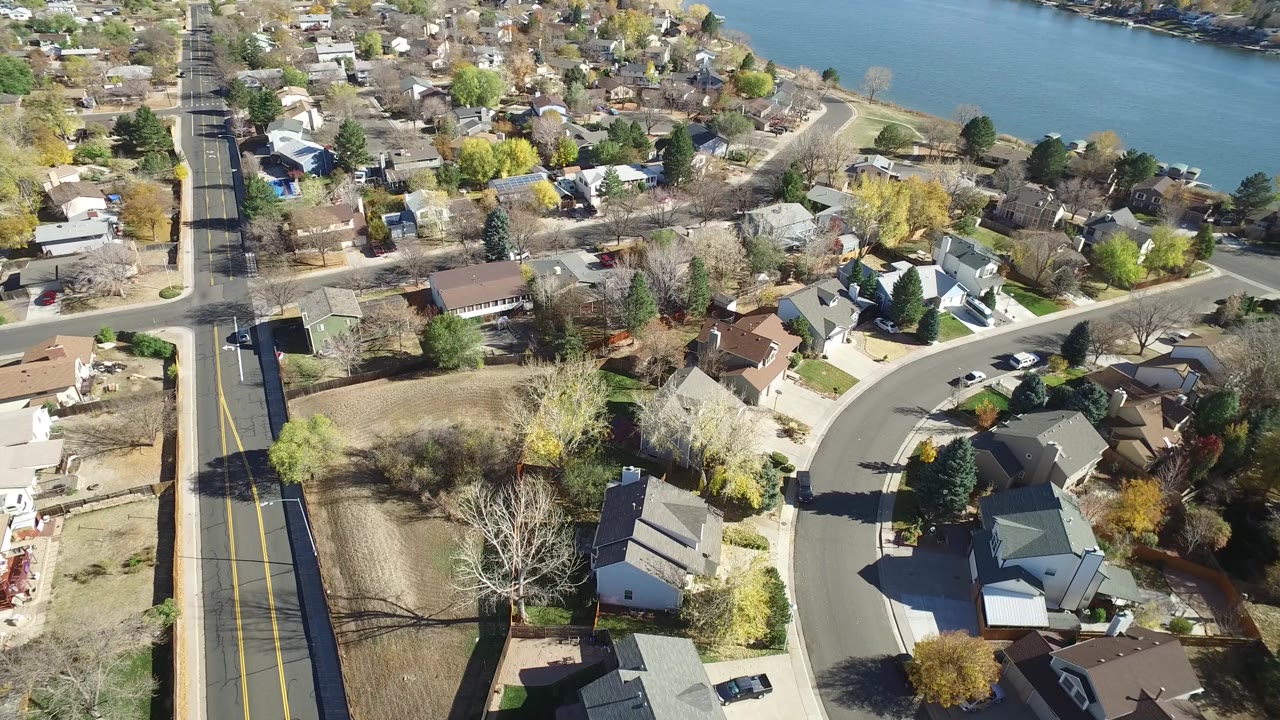 Drone-style view of a suburban block beside blue water.