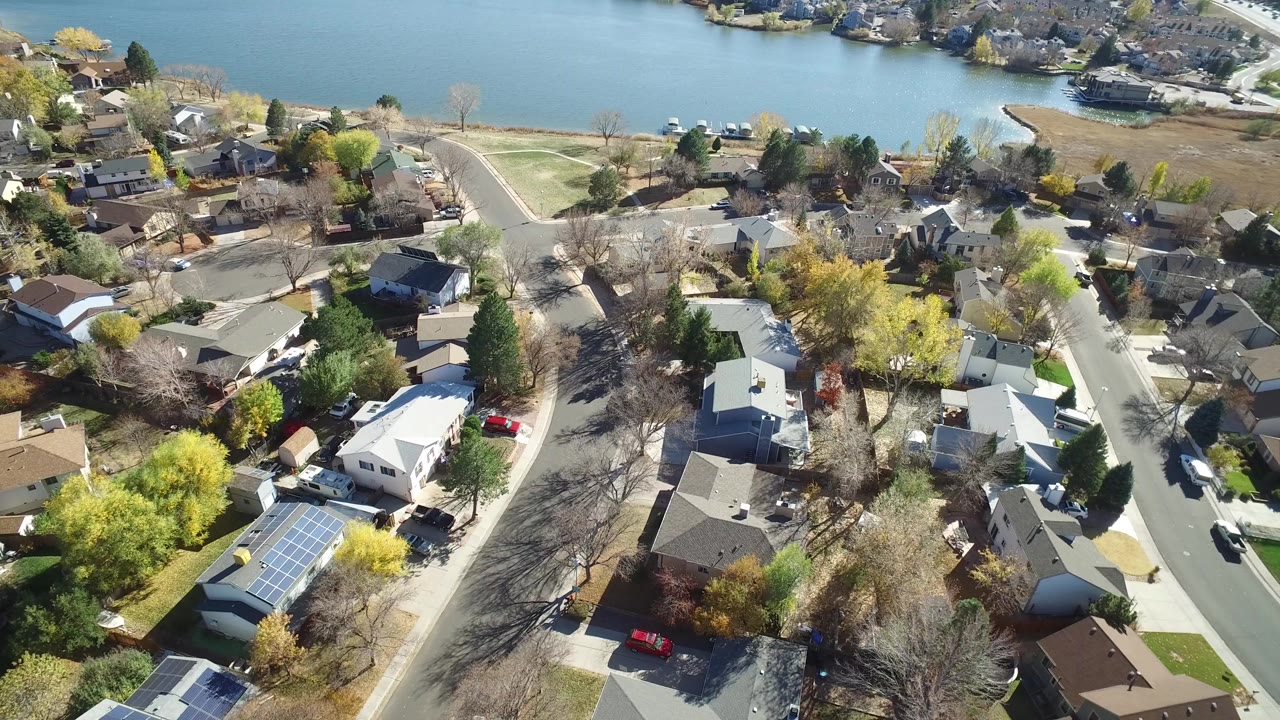 High-angle view of suburban homes beside a lake.