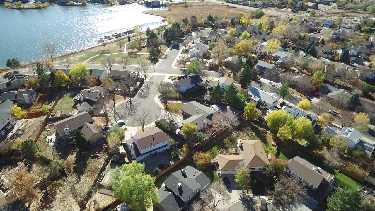 Aerial view of lakeside suburban homes and tree-lined streets.