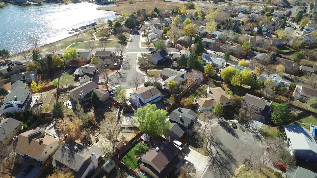 Aerial view of houses and roads beside a bright lake