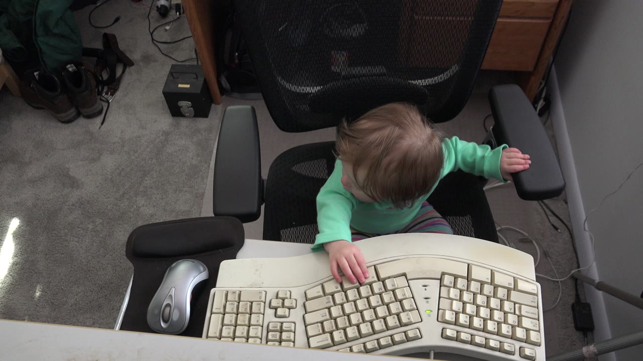 Child sitting behind a large beige keyboard at a desk