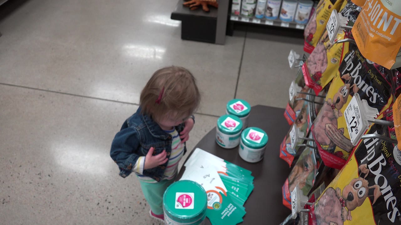 Toddler standing beside retail product display