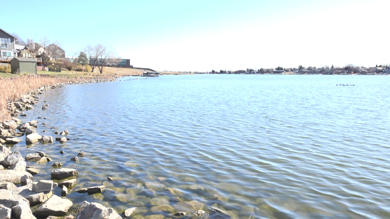 One second into the Hidden Lake, Colorado clip, small surface ripples cross the water while foreground rocks and the left shoreline remain visible with no visible people.