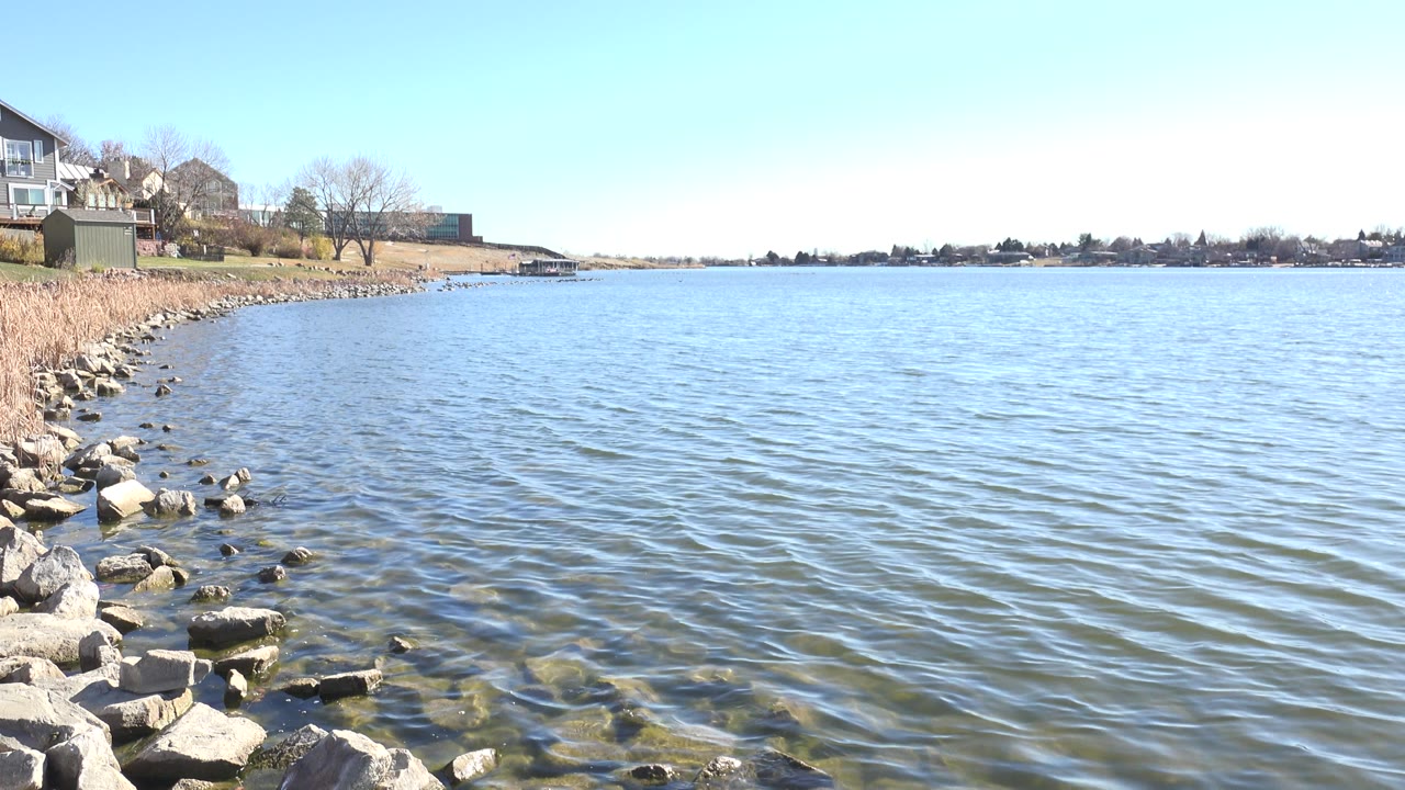 Rocky lake bank with rippled water and distant shoreline