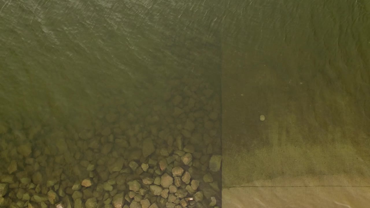 Overhead water surface with rocks concentrated near the lower right.