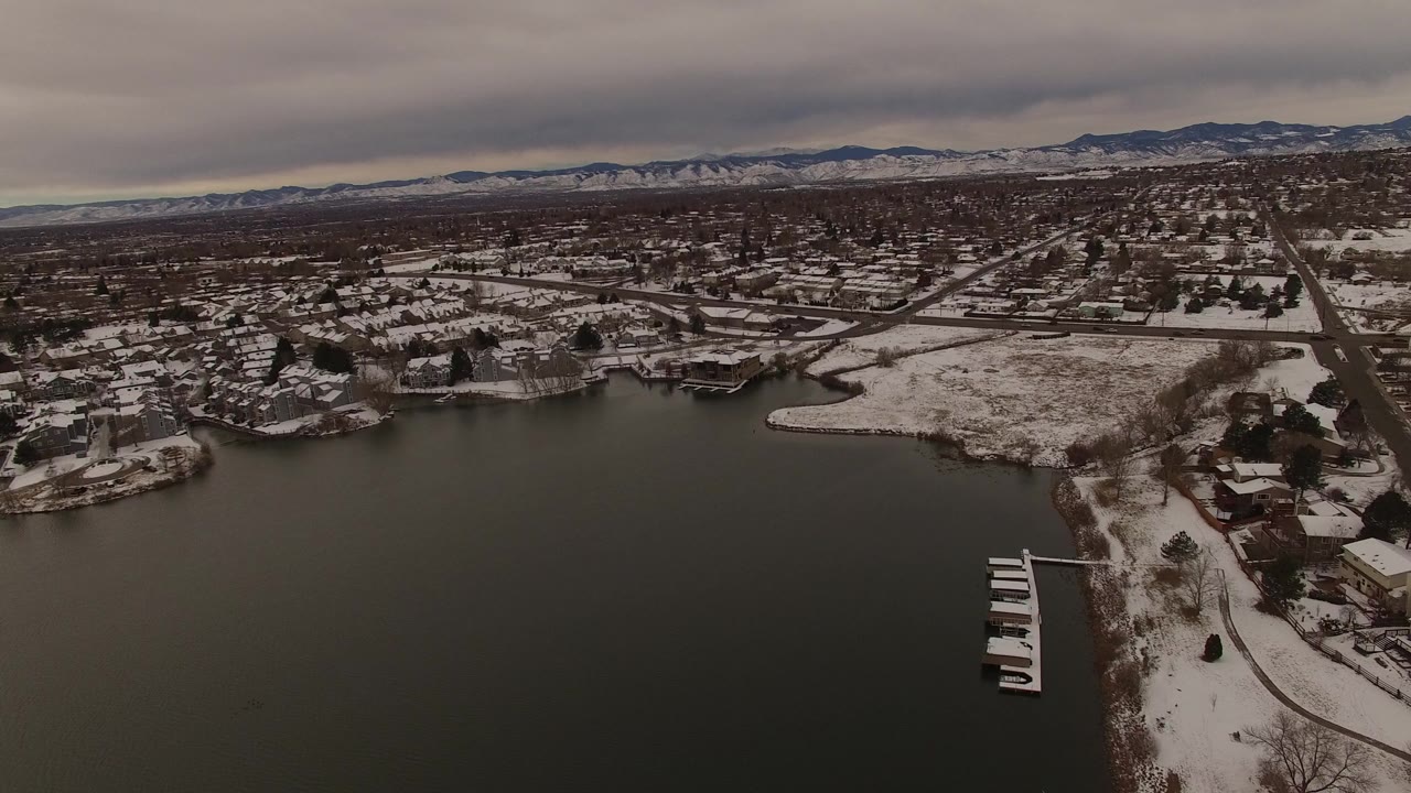 Snowy lakeside neighborhood under gray clouds