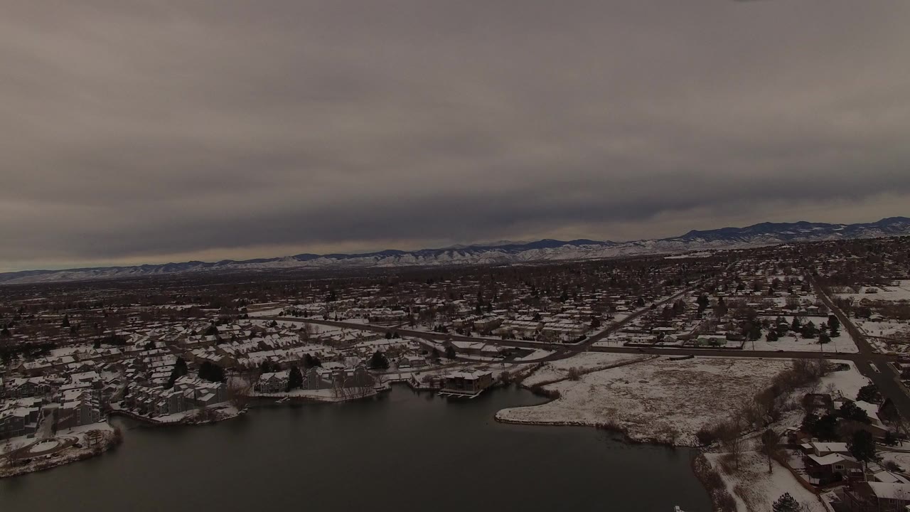 Snowy lakeside neighborhood under low gray clouds