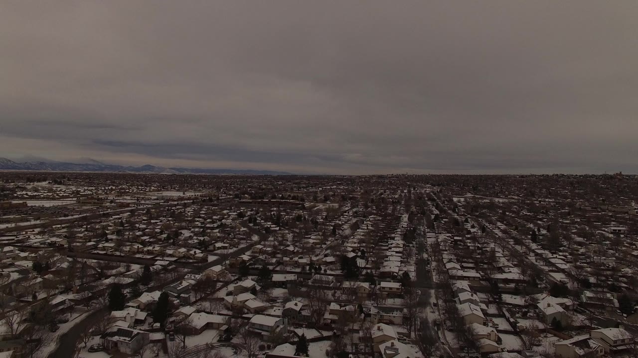 Wide winter suburb with mountains on the horizon