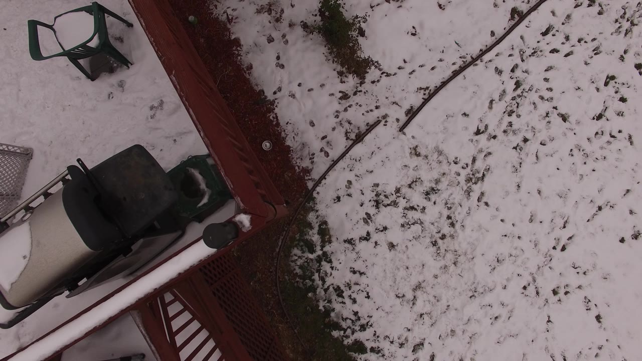 Top-down frame of the Jefferson, Colorado backyard with a red fence crossing the scene, snow patches, a chair, and no visible people.