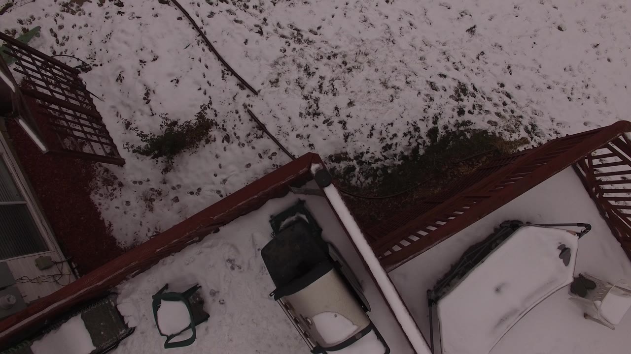 Overhead snowy backyard with red railing and patio furniture